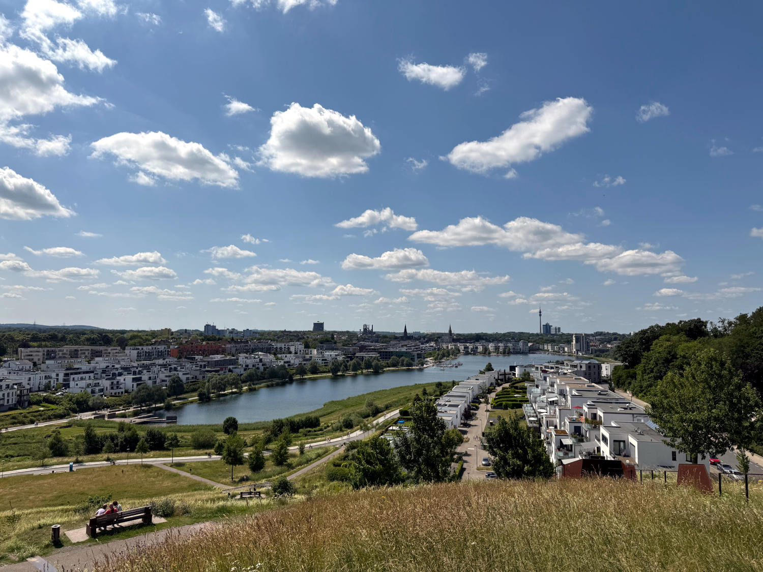 Blick vom Hügel oberhalb des Phoenixsees auf den See, blauer Himmel, Schäfchenwolken