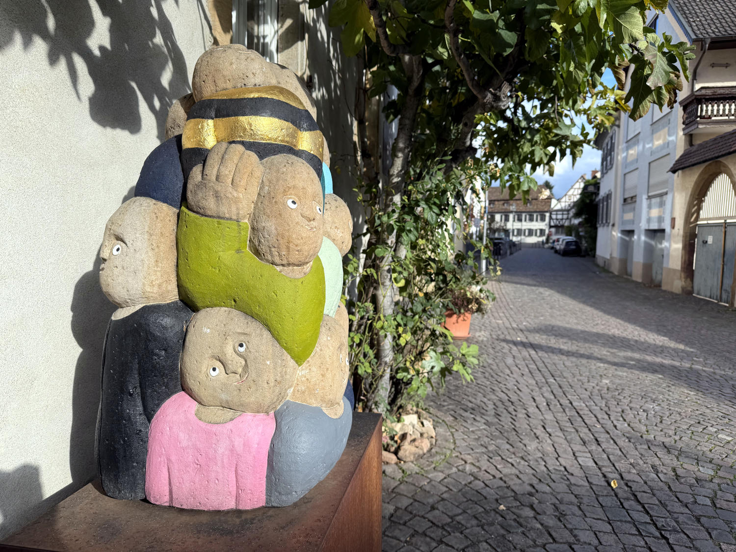 Eine Steinmetzarbeit: mehrere eineinandergefügte runde Figuren, bemalt in Bunt und Gold.