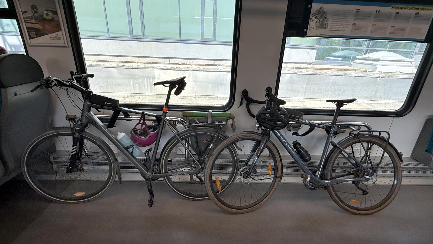 Zwei Fahrräder im Zug an ihren Stellplätzen, angegurtet.