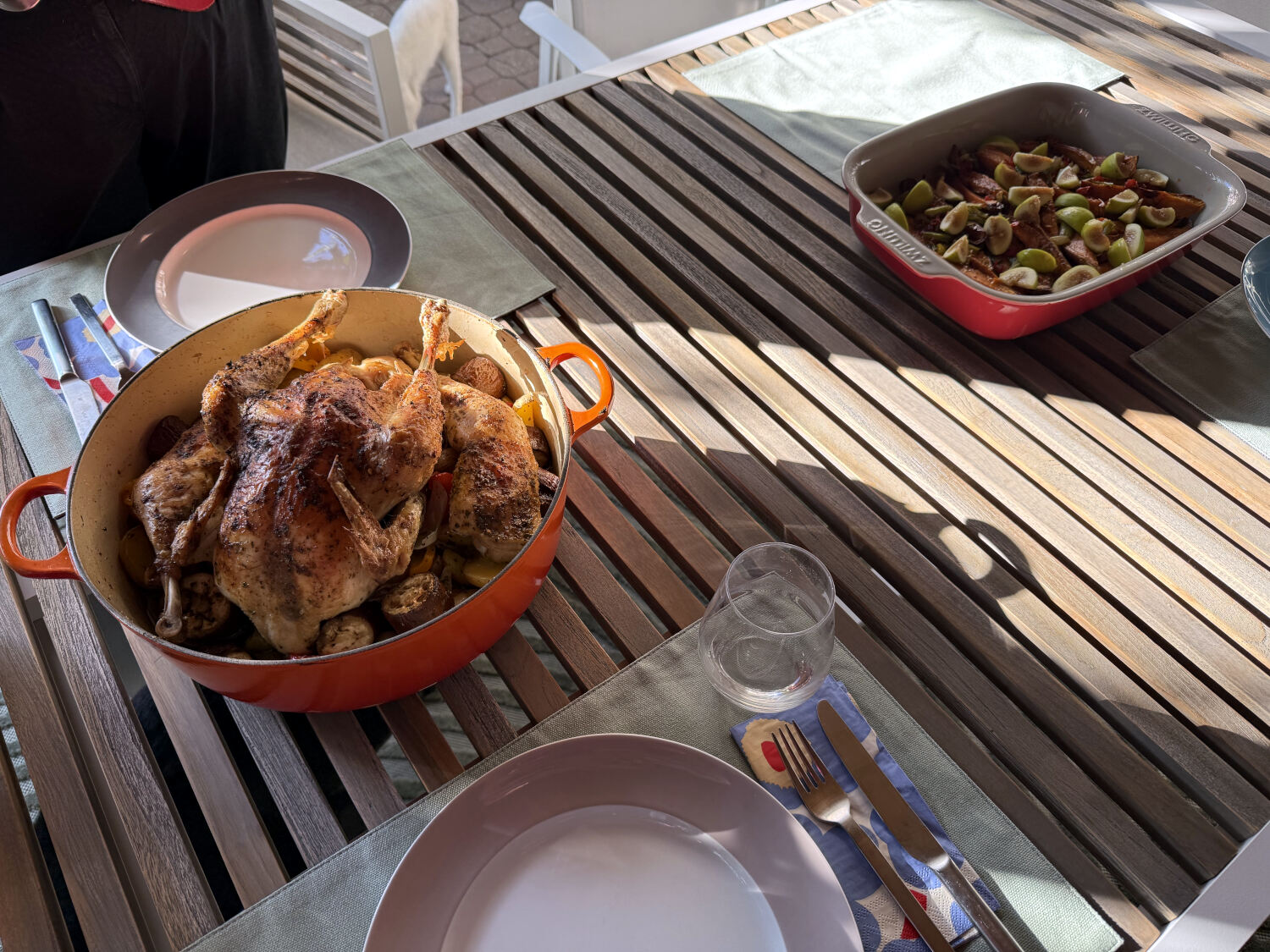 Ein Huhn in einem Topf, darunter Kartoffeln und Gemüse, daneben Süßkartoffeln mit Feigen.