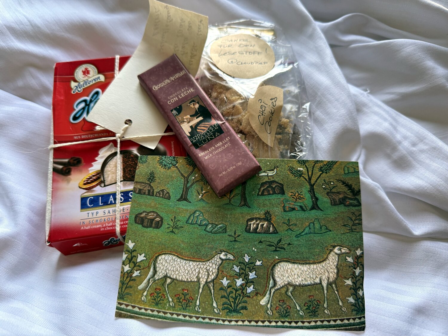 Halloren-Kugeln, selbstgebackene Kekse, Schokolade und eine Postkarte mit Schafen.